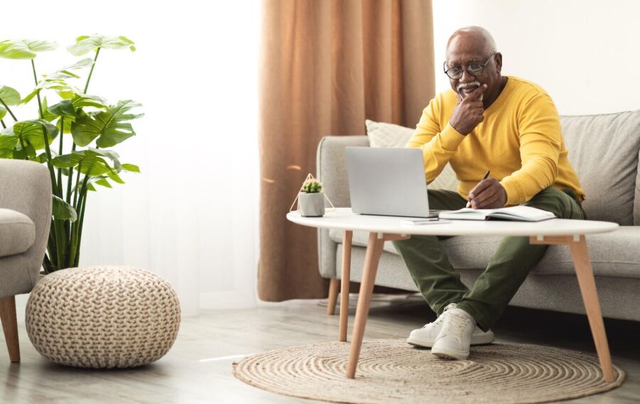 Homem buscando informações online e anotando. Reprodução: Internet