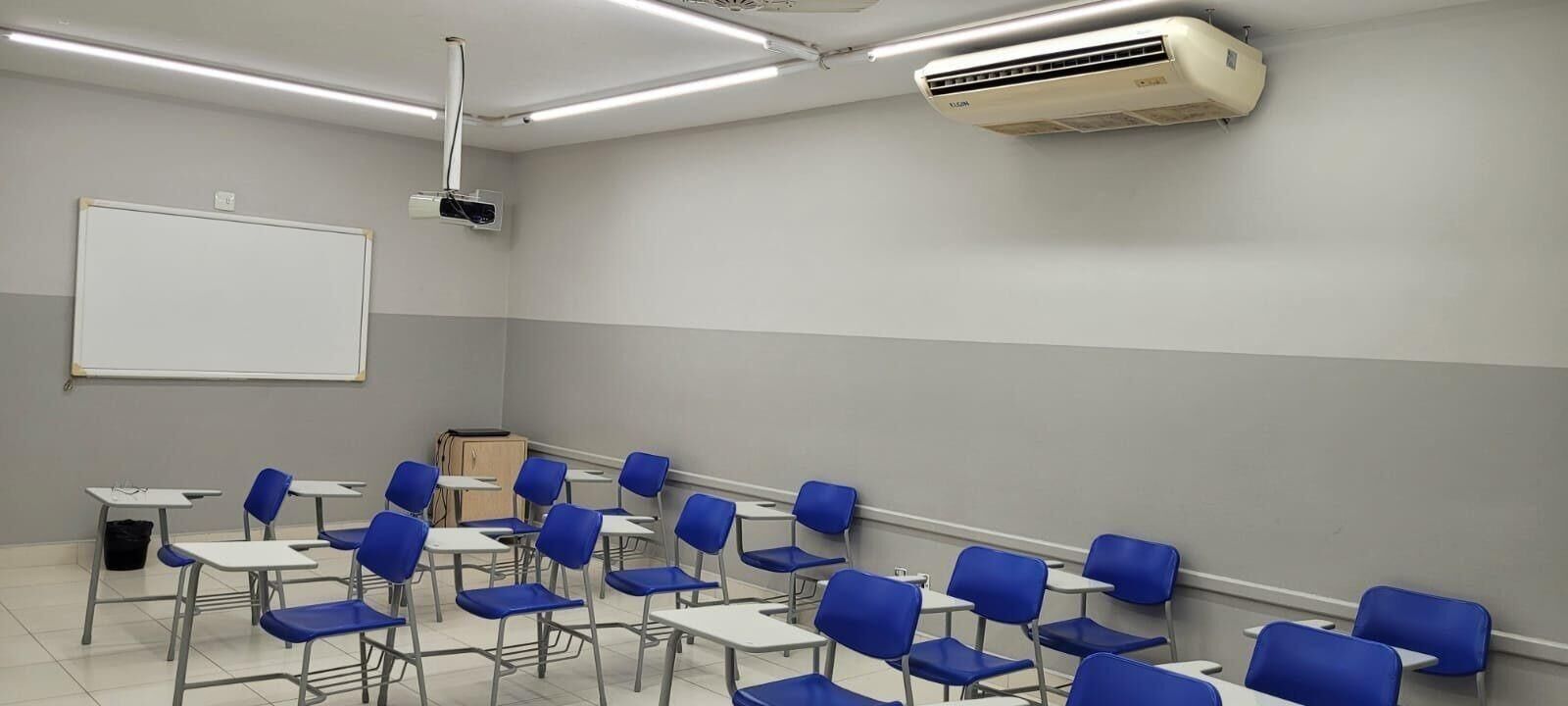 Sala de aula com carteiras azuis e ar-condicionado