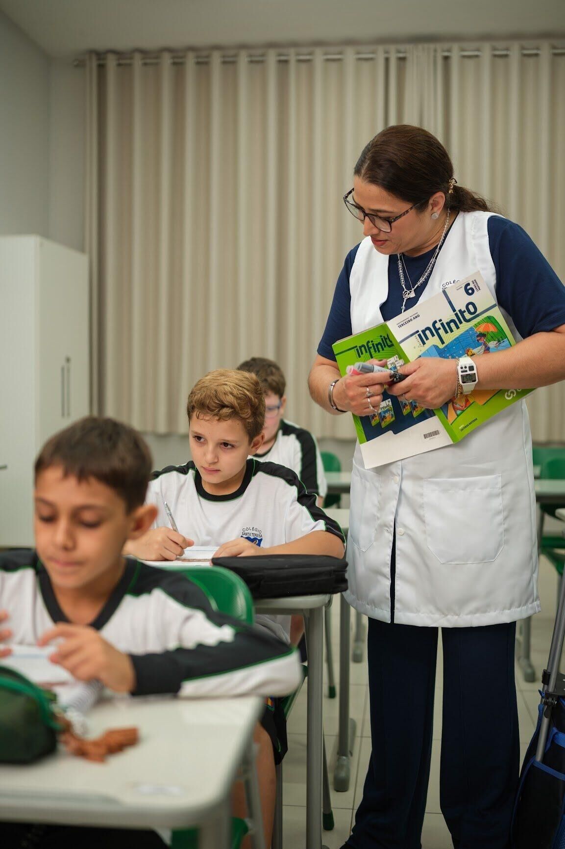 Professora orientando alunos na carteira