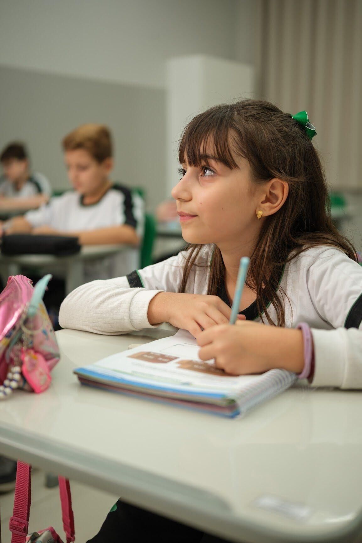 Aluna dos Anos Iniciais escrevendo no caderno em sala