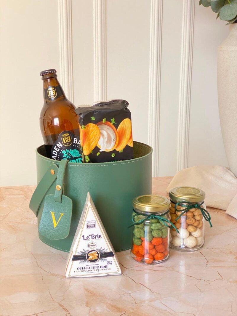Caixa verde com cerveja artesanal, queijo e potes de conserva