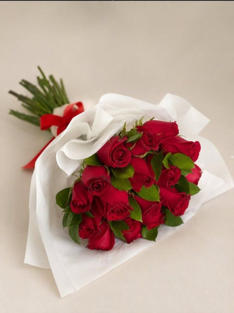 Buquê de rosas vermelhas embrulhado em papel branco