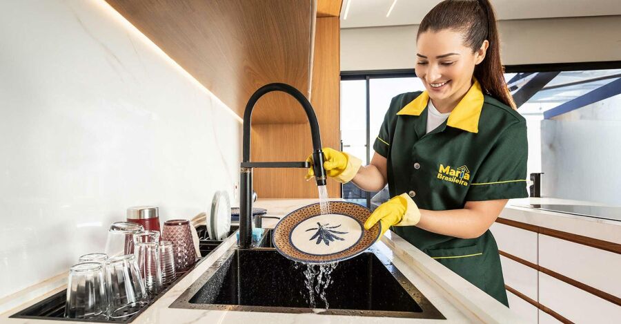 Profissional de limpeza da Maria Brasileira organizando a cozinha.